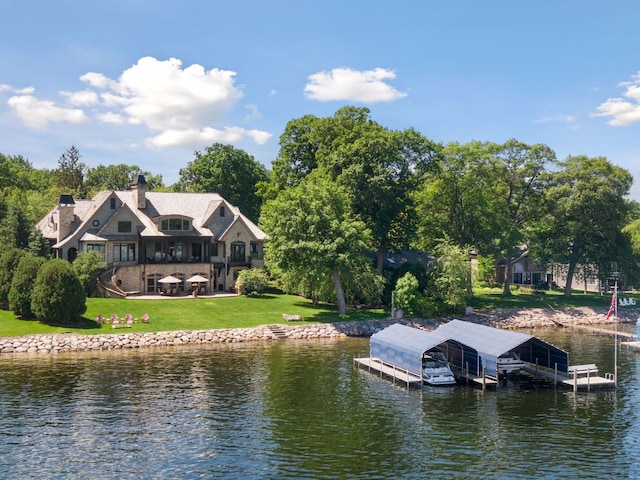 view of dock with a water view and a lawn