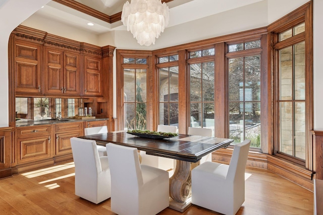 dining space featuring crown molding, recessed lighting, light wood-type flooring, and a notable chandelier