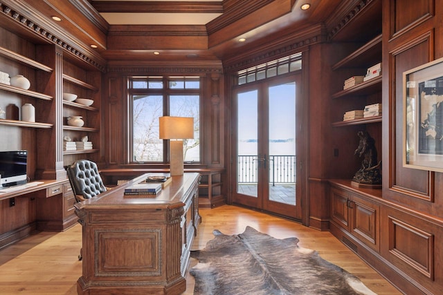 home office with light wood finished floors, ornamental molding, and french doors