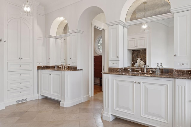 bar with a chandelier, hanging light fixtures, a sink, and backsplash