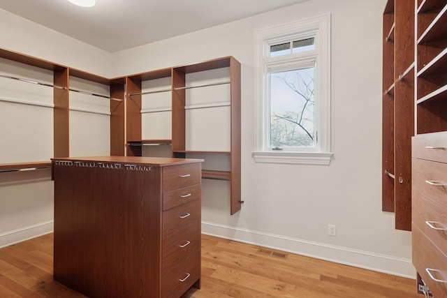 spacious closet with light wood-style floors and visible vents