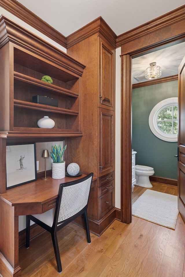 office space with ornamental molding, light wood-type flooring, and baseboards