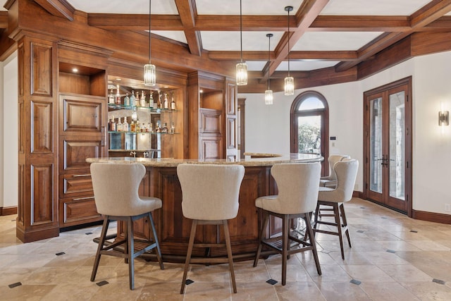 bar with hanging light fixtures, baseboards, coffered ceiling, and french doors