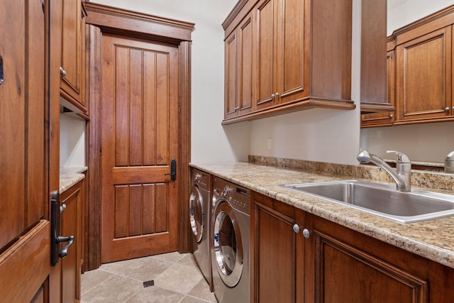 laundry area with washing machine and dryer, a sink, and cabinet space