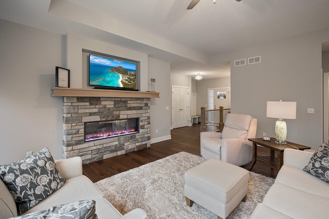 living room featuring a fireplace, wood finished floors, visible vents, and baseboards