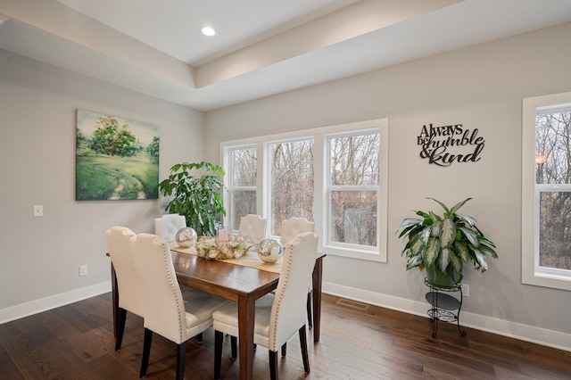 dining space with dark wood-style floors, visible vents, and baseboards