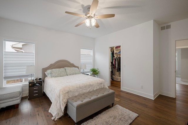 bedroom featuring multiple windows, visible vents, and dark wood-style flooring