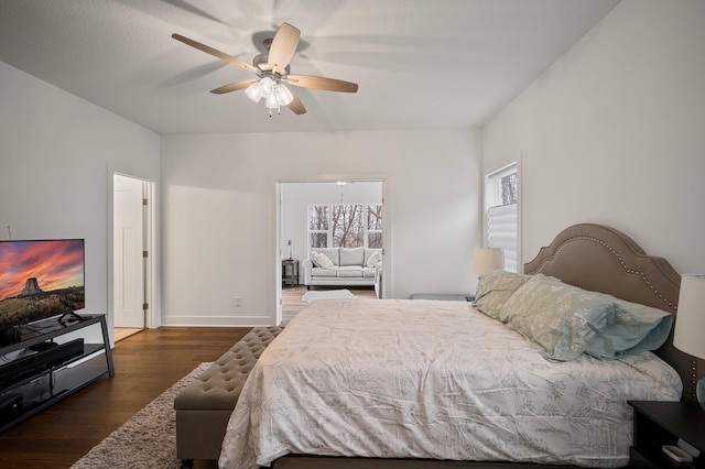 bedroom with dark wood-style flooring, a ceiling fan, and baseboards