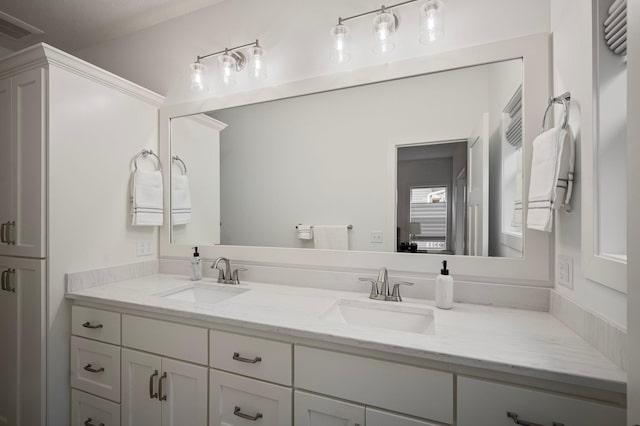 bathroom featuring visible vents, a sink, and double vanity