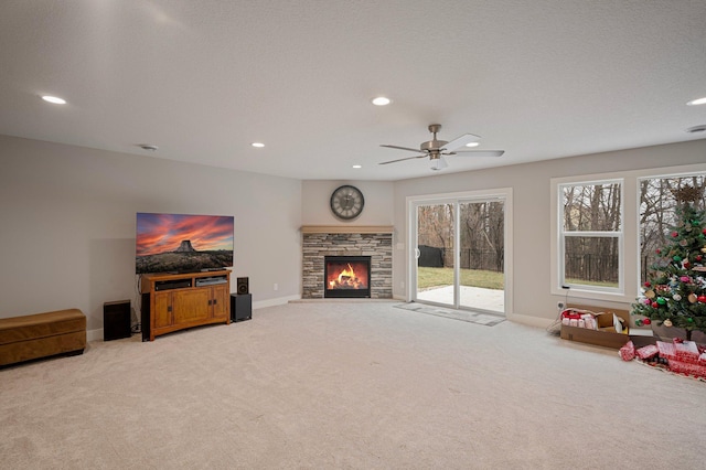 living area with a textured ceiling, a stone fireplace, recessed lighting, carpet floors, and baseboards