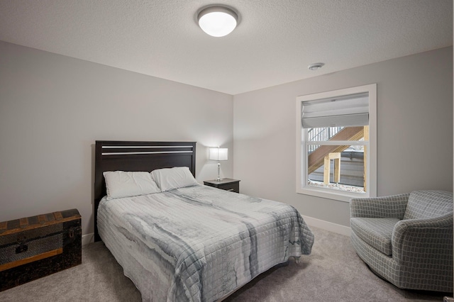 bedroom featuring a textured ceiling, baseboards, and carpet flooring