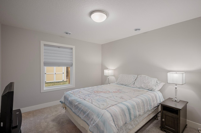 bedroom with light colored carpet, a textured ceiling, and baseboards