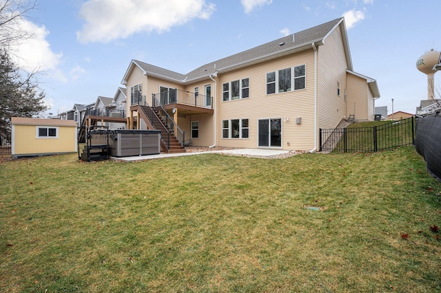 back of house with a fenced backyard, an outdoor structure, stairs, a patio area, and a hot tub