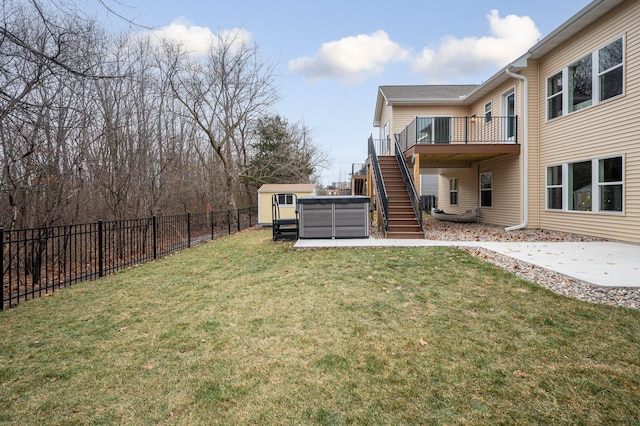 view of yard with a hot tub, a patio area, a fenced backyard, an outdoor structure, and stairs