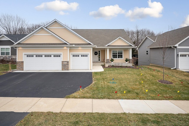 craftsman-style house featuring driveway, a shingled roof, a front lawn, stone siding, and a garage