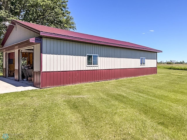 view of side of property featuring metal roof and a lawn