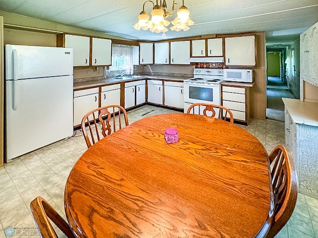 kitchen featuring pendant lighting, a notable chandelier, white cabinets, white appliances, and under cabinet range hood