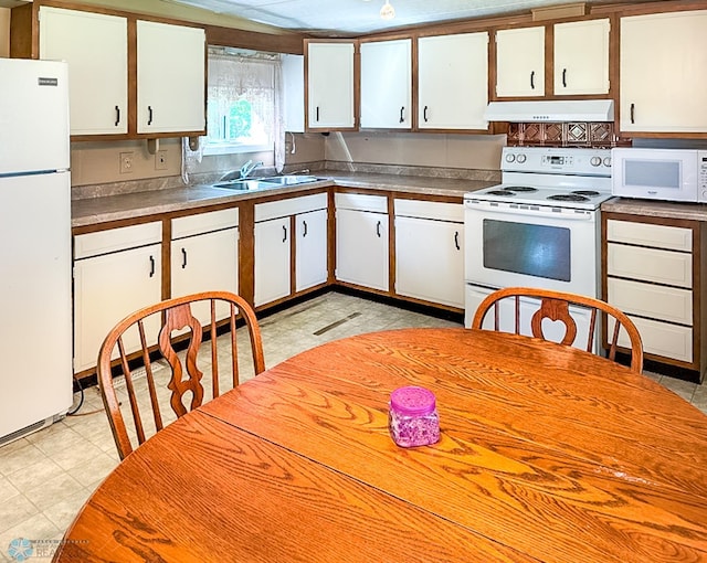 kitchen with white appliances, white cabinets, and under cabinet range hood