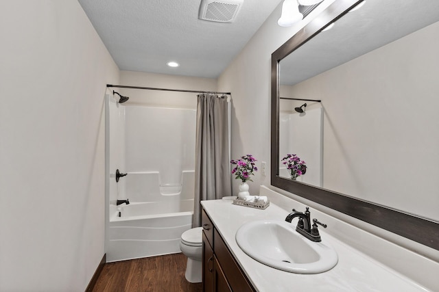 bathroom with vanity, wood finished floors, visible vents, shower / tub combo, and toilet