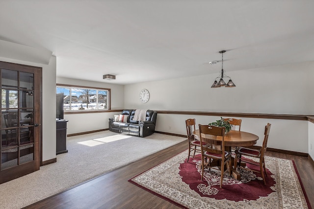 dining space with baseboards and wood finished floors