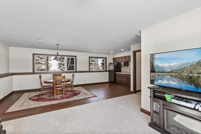 dining room with dark wood-type flooring, baseboards, and dark carpet