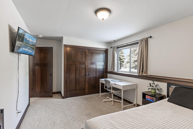 carpeted bedroom featuring a closet and baseboards