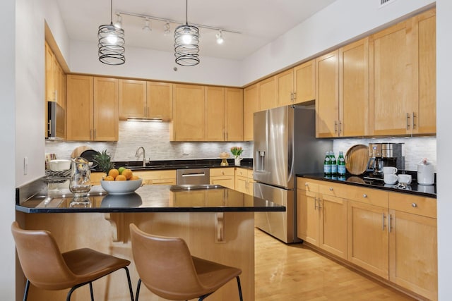 kitchen with dark countertops and light brown cabinetry