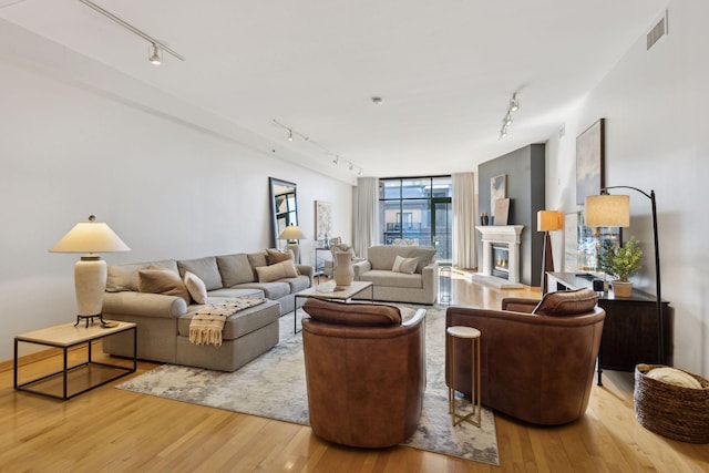 living area featuring track lighting, visible vents, and light wood-style floors