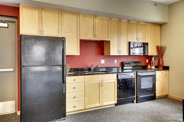 kitchen with dark countertops, a sink, black appliances, and light brown cabinetry