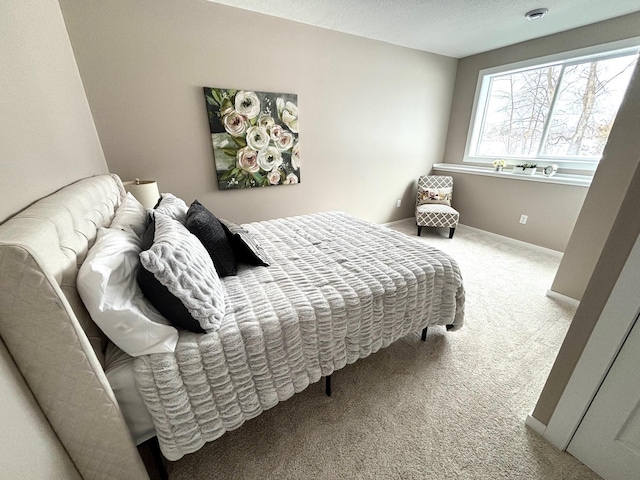 bedroom with carpet, baseboards, and a textured ceiling