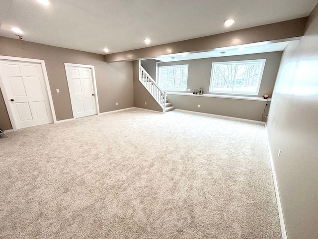 below grade area featuring carpet, stairway, baseboards, and recessed lighting