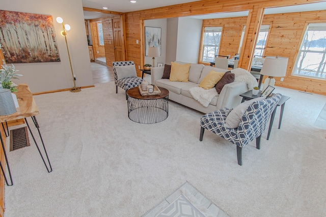 living area with recessed lighting, light carpet, wood walls, visible vents, and baseboards