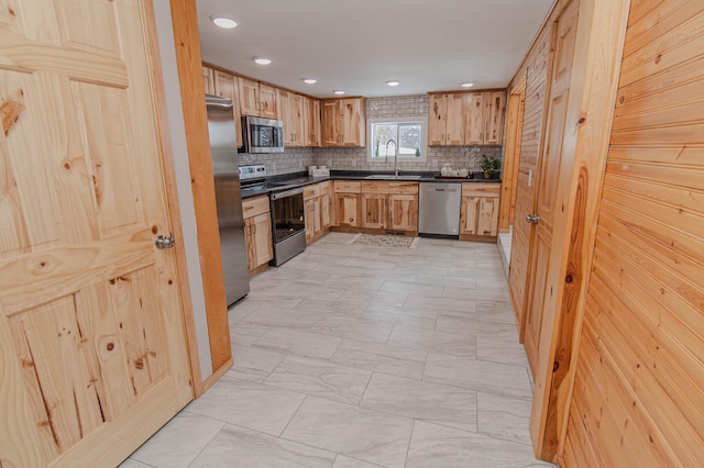 kitchen with decorative backsplash, dark countertops, appliances with stainless steel finishes, a sink, and recessed lighting