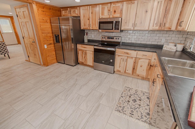 kitchen featuring stainless steel appliances, dark countertops, recessed lighting, tasteful backsplash, and a sink