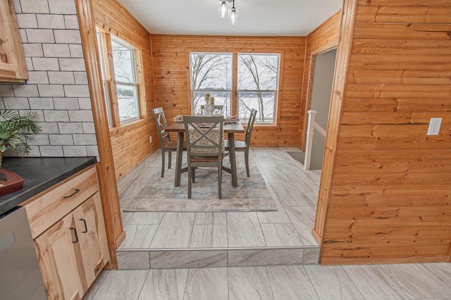 dining space with a healthy amount of sunlight and wooden walls