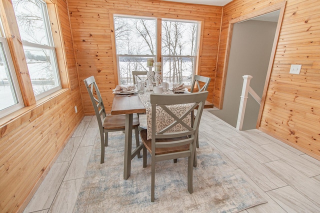 dining room with plenty of natural light and wooden walls