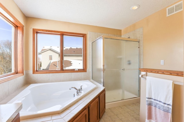 full bath with a stall shower, visible vents, a textured ceiling, and vanity