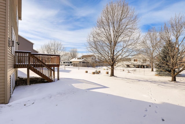 yard covered in snow with stairway and a wooden deck