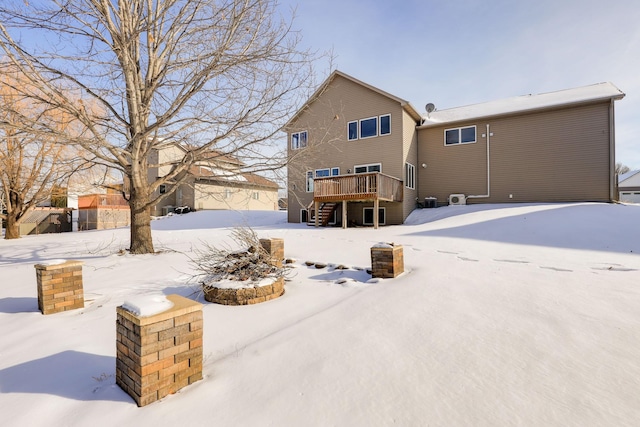 snow covered property with a deck and stairway