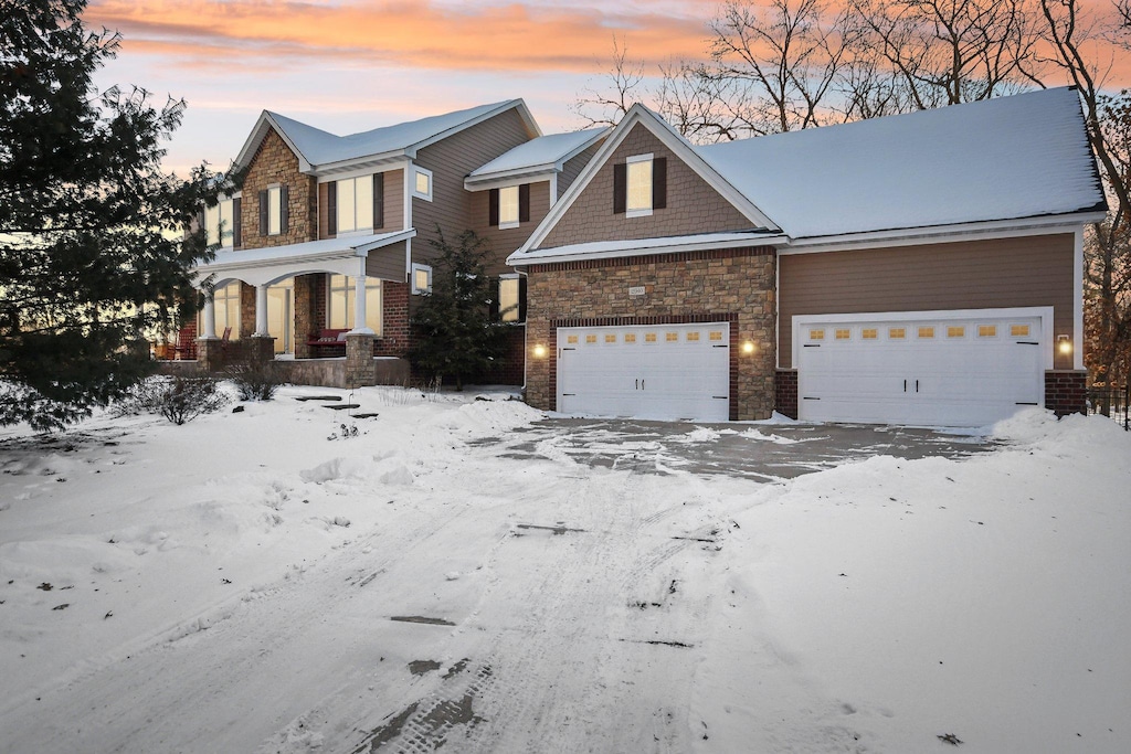 view of front of property with a garage and stone siding