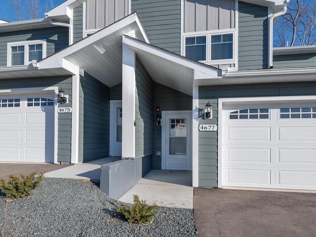 view of exterior entry featuring board and batten siding and an attached garage