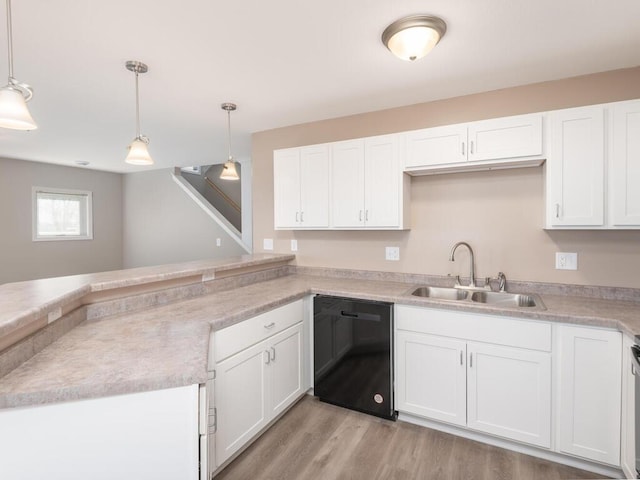 kitchen featuring white cabinetry, light countertops, dishwasher, and decorative light fixtures