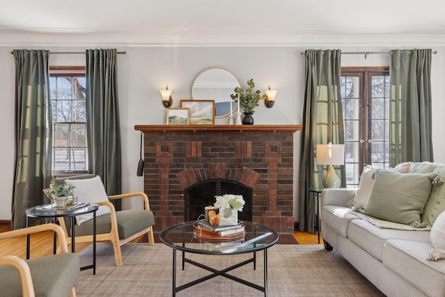 living area featuring light wood-style floors, a fireplace, and ornamental molding