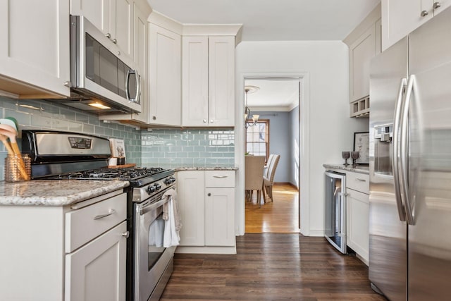 kitchen featuring stainless steel appliances, beverage cooler, and white cabinets