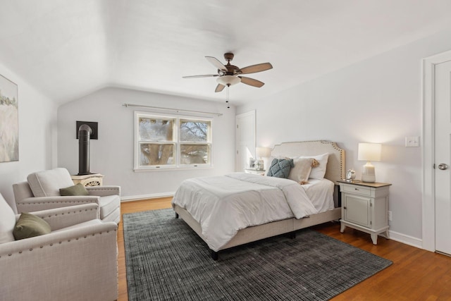 bedroom with ceiling fan, baseboards, vaulted ceiling, and wood finished floors