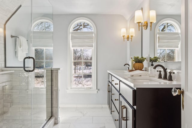 full bathroom featuring marble finish floor, a sink, a shower stall, and double vanity