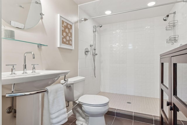 bathroom with tile patterned flooring, a tile shower, toilet, and recessed lighting