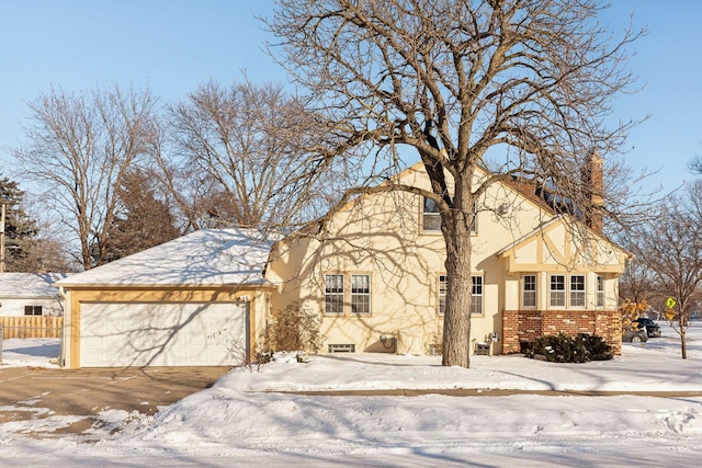 view of front of home featuring a garage, brick siding, and stucco siding