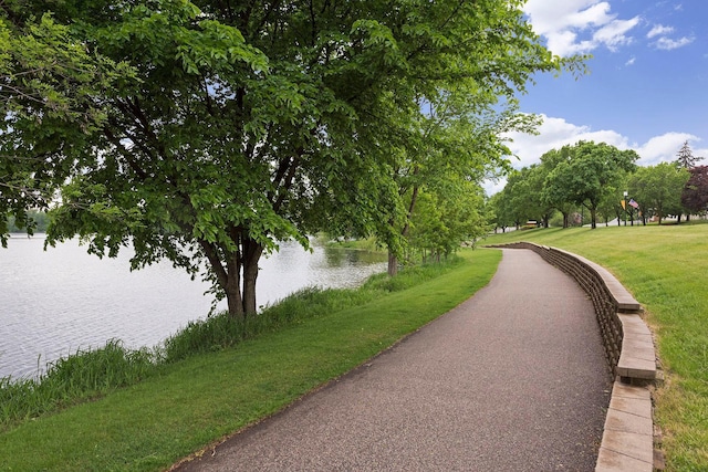 surrounding community with a lawn and a water view