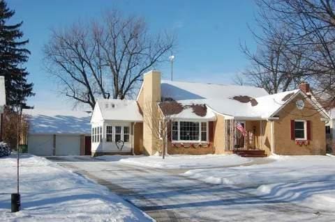 view of front of property with an outbuilding, a chimney, and a garage